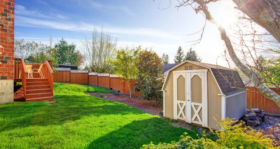 Fenced backyard with storage shed in Fort Smith